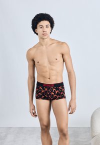 Boxeri negri cu model floral roșu și bandă elastică roșie cu textul "DIESEL". Materialul pare neted și elastic. Modelul este în poziție verticală.