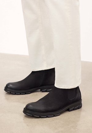 Botine negre până la glezna, din suede, cu un finisaj texturat, care au o talpă groasă din cauciuc și panouri elastice laterale pentru o îmbrăcare ușoară.