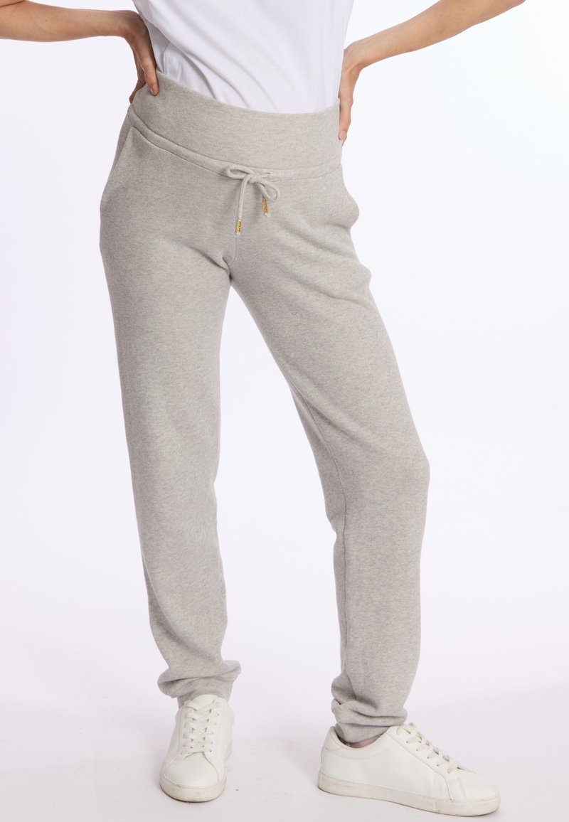 Lichtgrijze sweatpants met een brede elastische tailleband, trekkoordsluiting en taps toelopende enkelmanchetten. Zachte stof en minimale details.