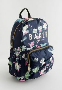 Rucsac floral marin cu accente aurii, curele ajustabile și mai multe buzunare cu fermoar. Prezintă un model floral vibrant pe un material texturat.