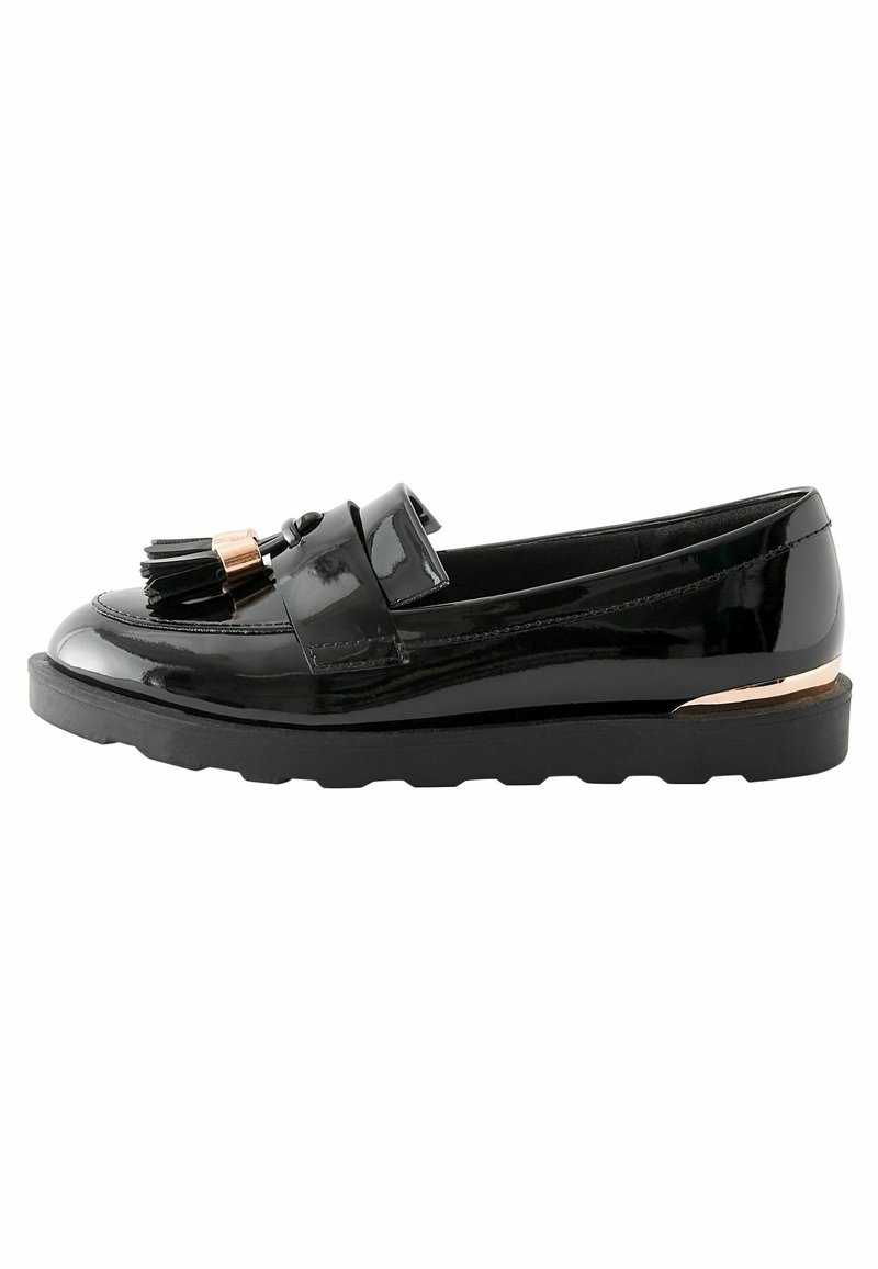 Mocassini in vernice nera con suola a piattaforma, caratterizzati da un nappo decorativo e un accent metallic sul tallone.