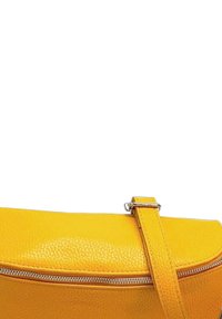 Geel leren handtas met een gestructureerd oppervlak, voorzien van een ritssluiting en een hengsel dat met zilveren hardware is bevestigd.