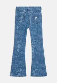 Uppvikta denimjeans i medelblått med blommönster, femfickorsdesign, metall-logotyp på bakfickan, mjuk textur.