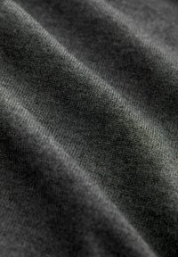 Tela gris oscuro con una textura suave y un sutil patrón de punto, que muestra pliegues y sombras para añadir profundidad.