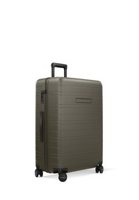 Valise rigide vert olive avec des rainures horizontales, roues pivotantes doubles, une poignée télescopique et une serrure à combinaison intégrée.