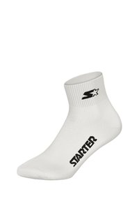 White ankle sock with ribbed cuff, featuring a black logo at the ankle and black text on the side. Made from a smooth, stretchy material.