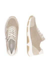 Baskets en suède beige avec des accents blancs, présentant une fermeture éclair sur le côté, un devant à lacets et une semelle en caoutchouc épaisse. Tige texturée avec des détails lisses.