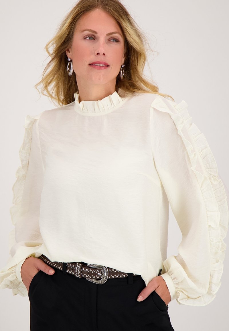Witte blouse met ruches mouwen en een hoge hals, gemaakt van lichtgewicht stof, gecombineerd met een zwarte riem met zilveren accenten.