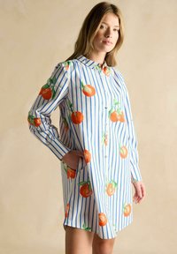 Gestreiftes Hemdkleid in Blau und Weiß, verziert mit orangen Fruchtprints. Hat lange Ärmel, einen Knopfverschluss vorne und Seitentaschen.