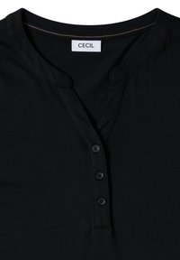 Chemise noire de style Henley avec trois boutons, encolure ronde avec une légère découpe en V, et étiquette de marque "CECIL" visible à l'intérieur du col.