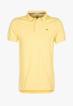 Polo en coton jaune doux avec un col classique, des manches courtes et un petit logo sur la poitrine. Doté d'un ourlet droit.