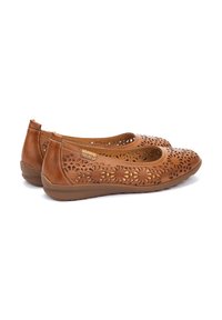 Bailarinas de cuero marrón con diseños florales recortados, punta redonda y suelas de goma flexibles para mayor comodidad. Textura suave y tacón bajo.