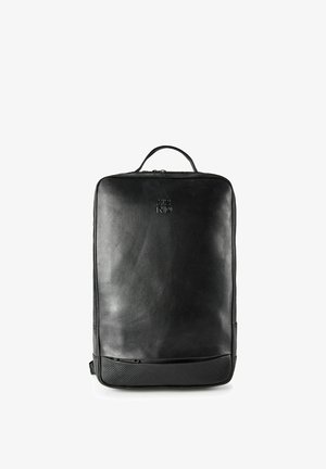 Mochila negra de cuero con textura suave, diseño rectangular, asa superior y un detalle inferior de goma con un patrón geométrico.