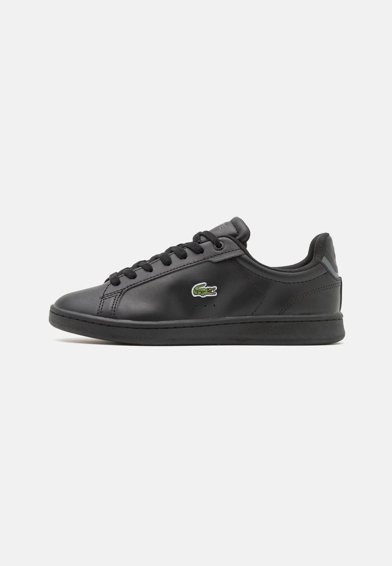 Fekete bőr sneaker sima felülettel, lekerekített orral, fűzős kialakítással és egy kis zöld krokodil logóval az oldalon.