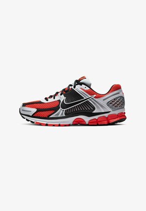 Zapatilla de correr para hombre en rojo, negro, blanco y gris con parte superior de malla, suela acolchada y logo Nike negro en el lateral.
