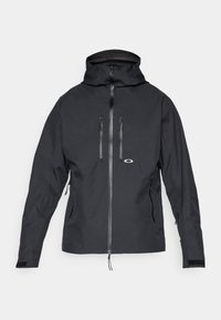 Black hooded waterproof jacket with front zipper, chest and side zippered pockets, and adjustable wrist straps.