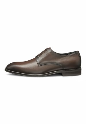 Chaussure habillée en cuir marron au design élégant, à bout pointu, texture lisse, à lazard à cinq œillets et talon bas empilé.