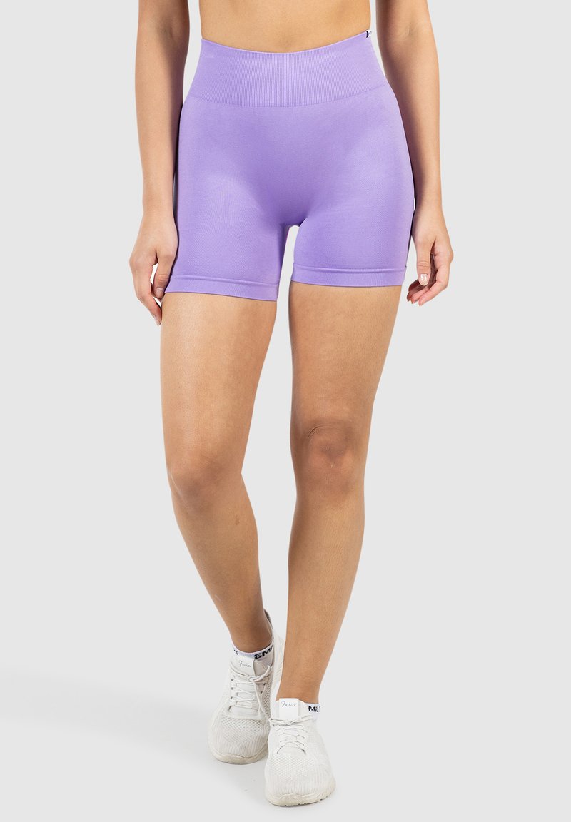 Lavendel hoge taille shorts van rekbaar materiaal. Zachte textuur met een aansluitend ontwerp, reikt tot halverwege de dijen, gecombineerd met witte sneakers.