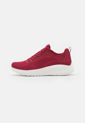 Scarpe da corsa rosse con tomaia in mesh testurizzato, suola bianca rigata, dettagli sintetici e linguetta rinforzata sul tallone per supporto.