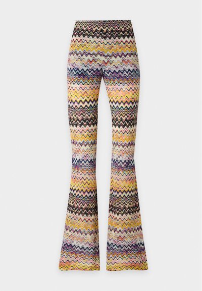 Pantalon taille haute évasé avec un motif zigzag multicolore dans des tons de jaune, rose, violet, noir et blanc sur un fond clair.