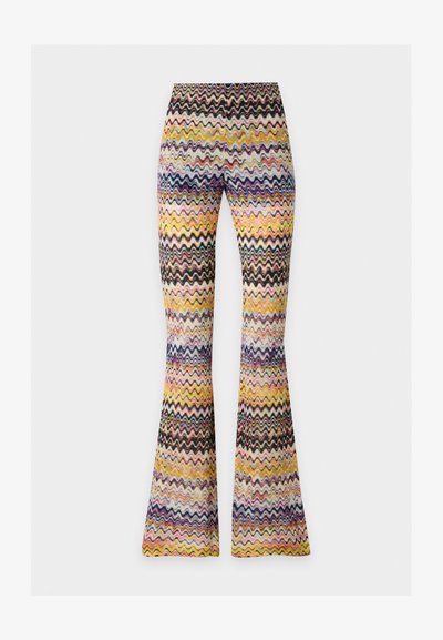 Pantalon taille haute évasé avec un motif zigzag multicolore dans des tons de jaune, rose, violet, noir et blanc sur un fond clair.