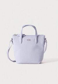 Ljubičasta teksturirana torbica s dvostrukim ručkama, uklonjivim naramenicom i zatvaračem na patentni zatvarač. Na prednjoj strani ima mali logo.