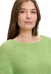 Helles grünes, gestricktes Sweatshirt mit weitem Ausschnitt und lockerem Sitz, aus strukturiertem Stoff und in lässigem Design.