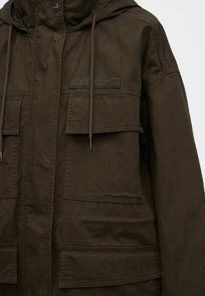 Veste vert olive foncé avec grandes poches à rabat sur le devant, cordons au col et étiquette en tissu « CLOSED » sur la poche poitrine.