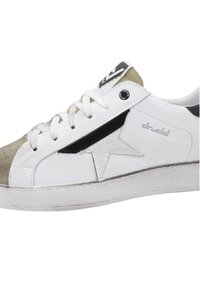White sneaker with suede grey toe cap, black detailing, and textured rubber sole. Features logo on tongue and star design on sides.