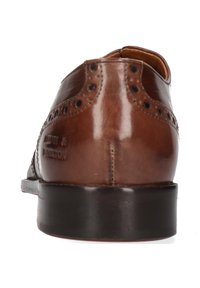 Chaussure habillée en cuir brun avec un design à bout fleuri, des détails en brogue et une finition lisse. Elle possède une semelle noire robuste et un logo en relief.
