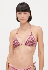 Brązowy i różowy zestaw bikini w kwiaty, który zawiera trójkątny stanik z regulowanymi ramiączkami oraz dół z wiązaniem po bokach. Wykonany z miękkiego, elastycznego materiału.