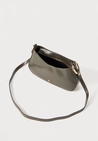Olive green leather handbag with a smooth finish, silver zip closure, and a detachable long strap. Features a small branded emblem on front.