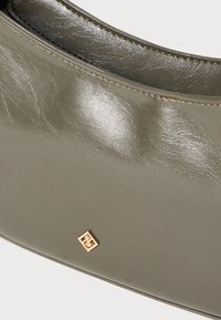 Olive green leather handbag with a smooth texture, featuring a gold accent logo and structured shape.