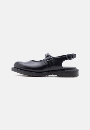 Black leather Mary Jane style shoe with two adjustable buckle straps and a thick, grooved rubber sole.