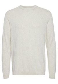 Suéter de punto suave en color beige claro con cuello redondo, que presenta mangas largas y un ajuste relajado, con puños y dobladillo acanalados. Sin patrones ni adornos.