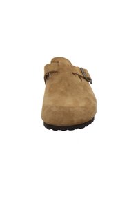 Beige Wildlederschuh mit runder Zehenform, ausgestattet mit einem einzelnen verstellbaren Riemen und einer silberfarbenen Schnalle. Strukturierte Oberfläche und Gummisohle.