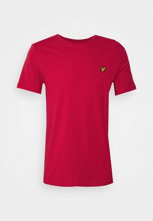 Czerwony t-shirt z krótkim rękawem i okrągłym dekoltem z małym żółto-czarnym logo ptaka na lewym piersi na jednolitym białym tle.