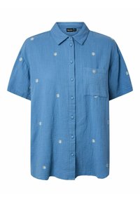Chemise bleue à manches courtes avec petits motifs de marguerites blanches et une poche poitrine.