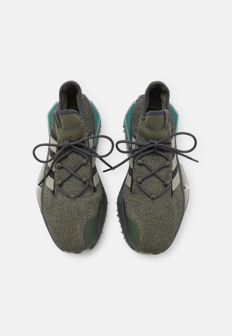 Zapatillas deportivas con parte superior de punto verde oliva, acentos negros y cordones grises. Presentan una suela gruesa con elementos en verde y beige.