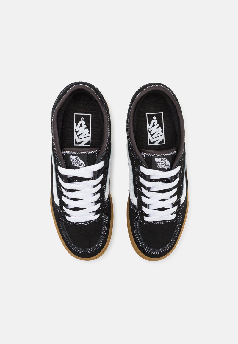 Zapatillas de ante en blanco y negro con cordones blancos y franjas laterales, que cuentan con una suela de goma y detalles de costura en contraste.