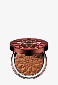Compatto di bronzer con un coperchio in rame sfaccettato, base argentata e logo "BY TERRY" in rilievo; la polvere interna è di un marrone caldo e texturizzato.