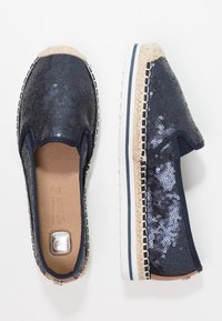 Espadrilles navy avec un dessus en sequins, bout arrondi, semelle intermédiaire en jute et semelle extérieure en caoutchouc. Couture décorative le long du bord, design à enfiler.