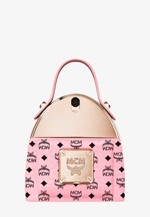 Pink og gylden MCM taske med topstrop, prydet med gentagne sorte logomønstre og en fremtrædende gylden logoplade foran.