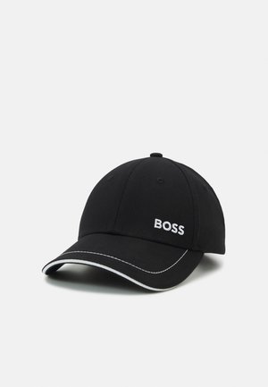 Črna bejzbol kapica z belim logotipom "BOSS". Ima ukrivljen vizir in kontrastno belo šivanje vzdolž roba vizirja. Klasičen dizajn.