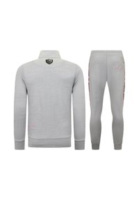 Grijze sweatshirt en bijpassende broek. De sweatshirt heeft een hoge kraag en een geborduurd logo; de broek heeft een accentstreep en logodetail.