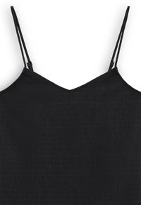 Svart camisole-top med tunna justerbara remmar, med en texturerad tyg som har subtila vertikala mönster och en v-formad halslinje.