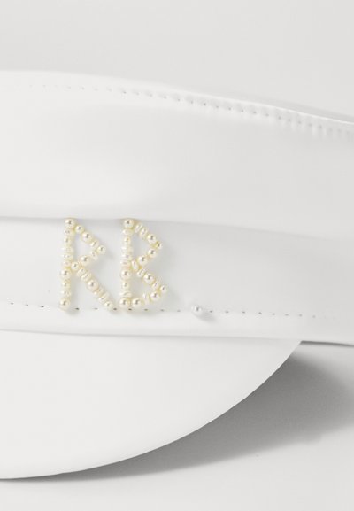 Valge visor-kork, millel on pärlitega aksessuaarid, mis moodustavad tähed "RB", ja pehme tekstuur, mille ääres on tikandiga detailid.