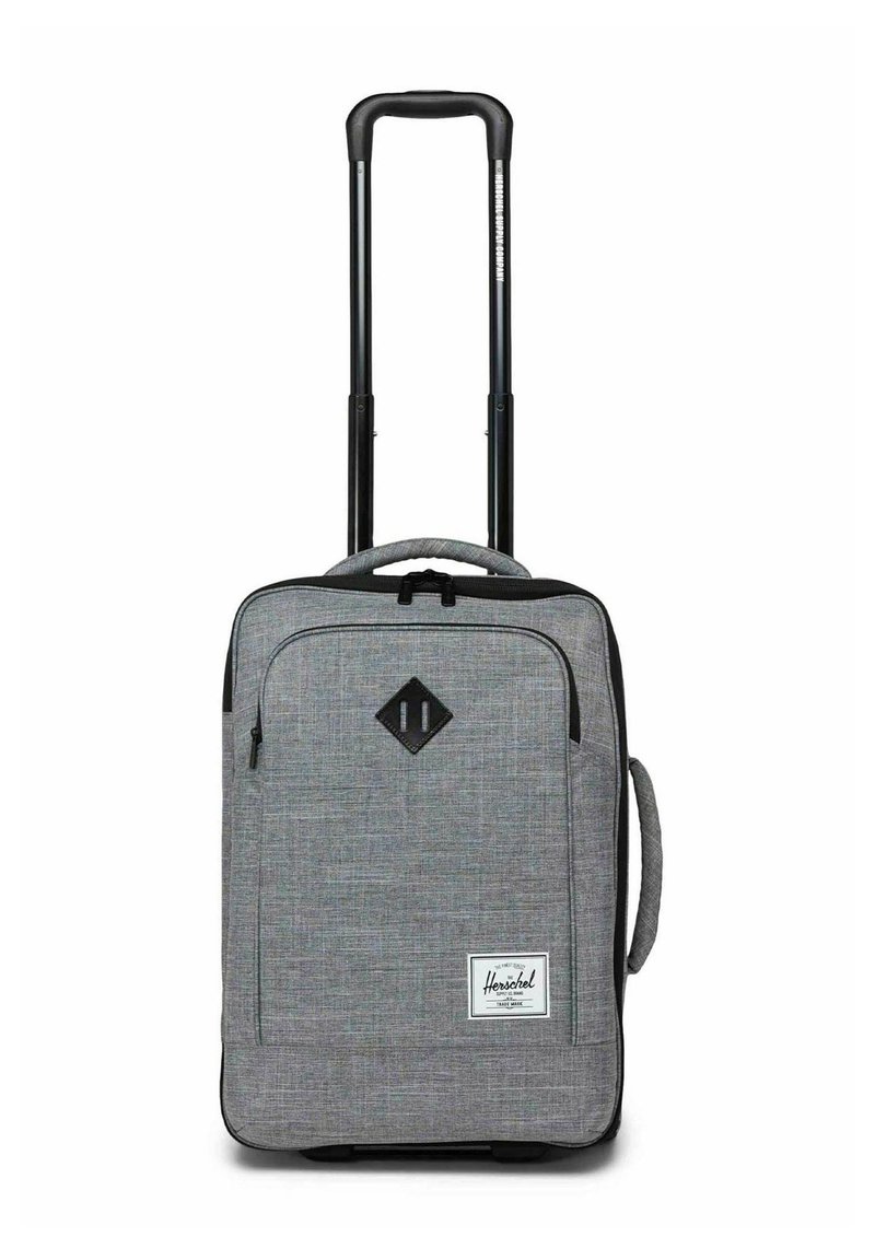 Valise cabine souple grise avec poignée rétractable noire, poche zippée sur le devant, poignée latérale et étiquette de marque Herschel à l'avant.