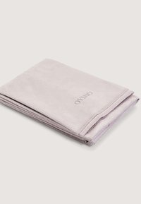 Světle fialová osuška z měkké tkaniny, úhledně složená s viditelným šitím a malým logem "OYSHO" na přední straně.