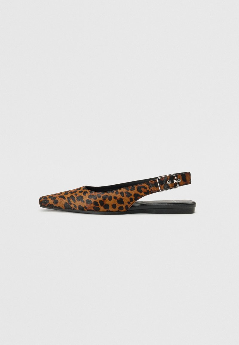 Zapatos planos slingback con estampado de leopardo, puntera afilada, acentos negros, correa ajustable y textura lisa, montados sobre una suela negra baja.